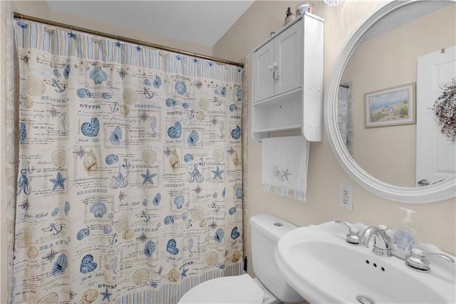 bathroom with toilet, a shower with curtain, and a sink