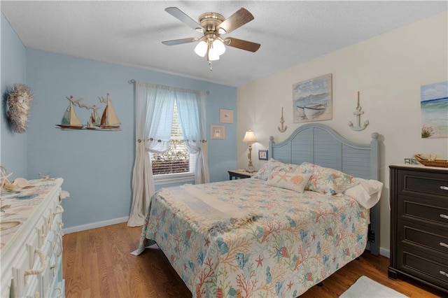 bedroom featuring wood finished floors, a ceiling fan, and baseboards