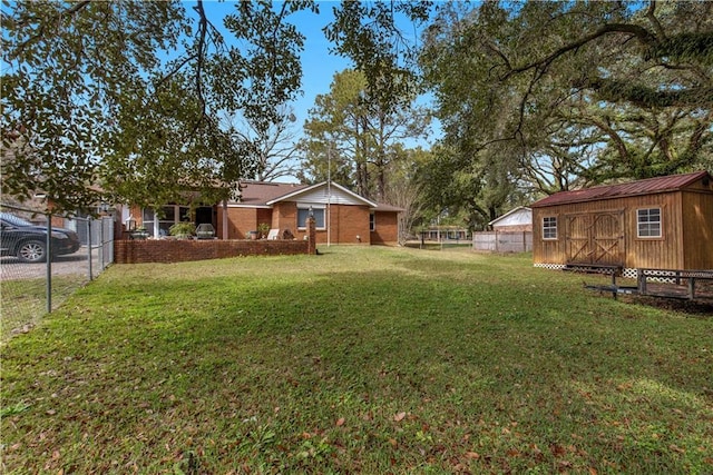 view of yard with a shed, fence, and an outbuilding