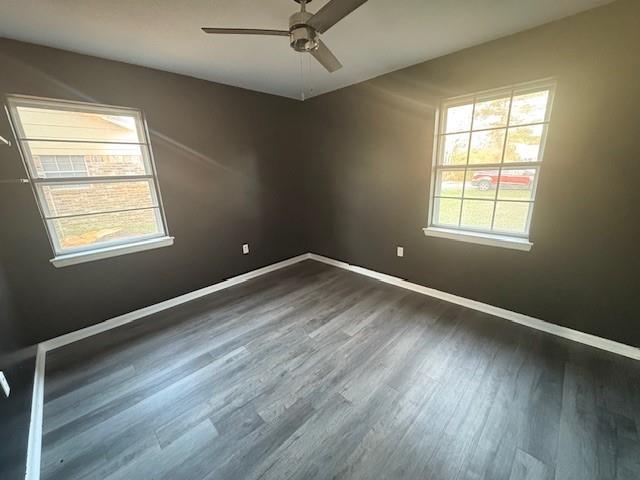 empty room featuring ceiling fan, wood finished floors, and baseboards