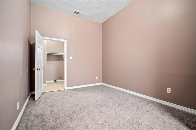 unfurnished bedroom with carpet floors and a textured ceiling