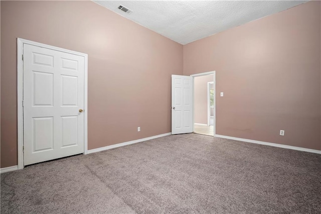 carpeted spare room with a high ceiling and a textured ceiling