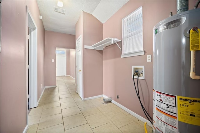 washroom featuring hookup for a washing machine, light tile patterned floors, and water heater