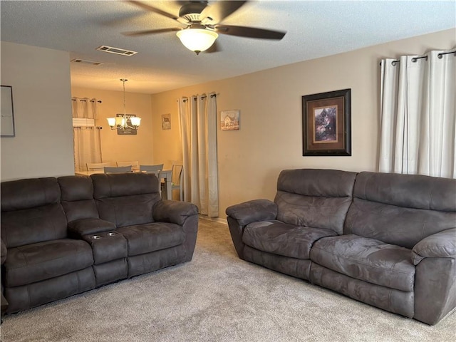 living room with light carpet, ceiling fan with notable chandelier, and a textured ceiling