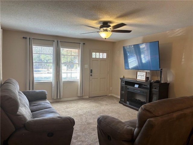 living room with ceiling fan, light colored carpet, and a textured ceiling