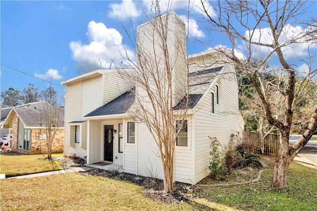 back of house with a lawn