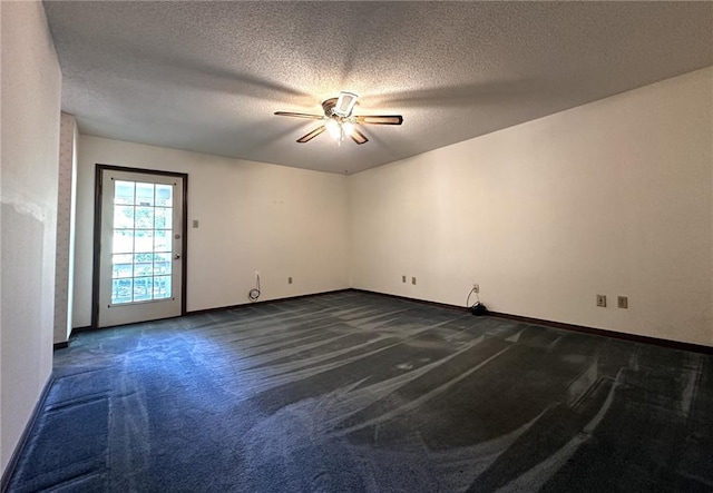 unfurnished room featuring a ceiling fan, baseboards, dark colored carpet, and a textured ceiling