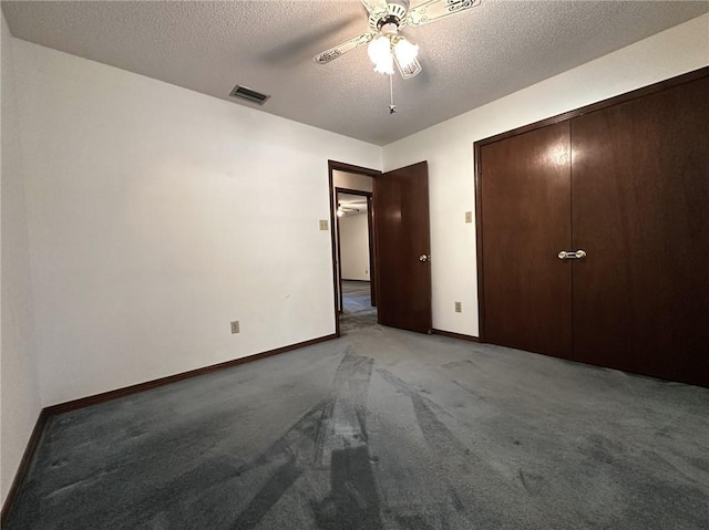 unfurnished bedroom featuring a ceiling fan, a textured ceiling, baseboards, carpet flooring, and visible vents