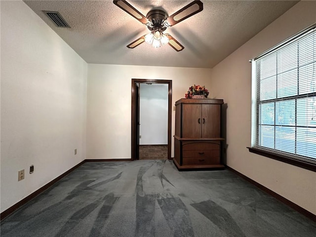 unfurnished bedroom featuring carpet flooring, a textured ceiling, visible vents, and baseboards