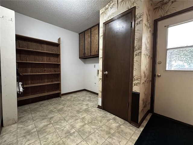 interior space with a textured ceiling and baseboards