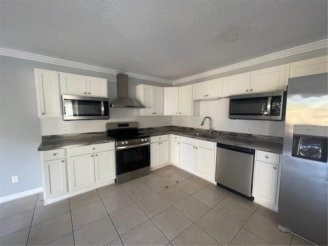 kitchen featuring sink, white cabinets, ornamental molding, stainless steel appliances, and wall chimney range hood