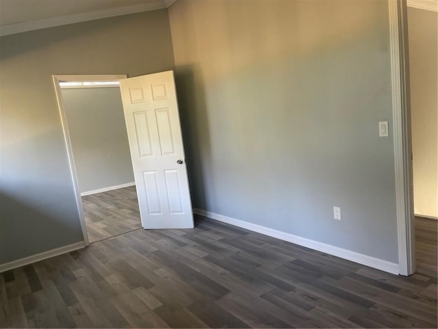 unfurnished room with dark hardwood / wood-style flooring and ornamental molding