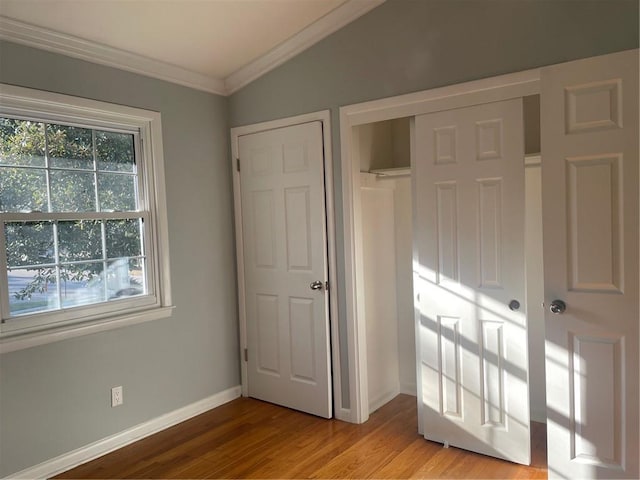 unfurnished bedroom featuring light hardwood / wood-style flooring, ornamental molding, and a closet