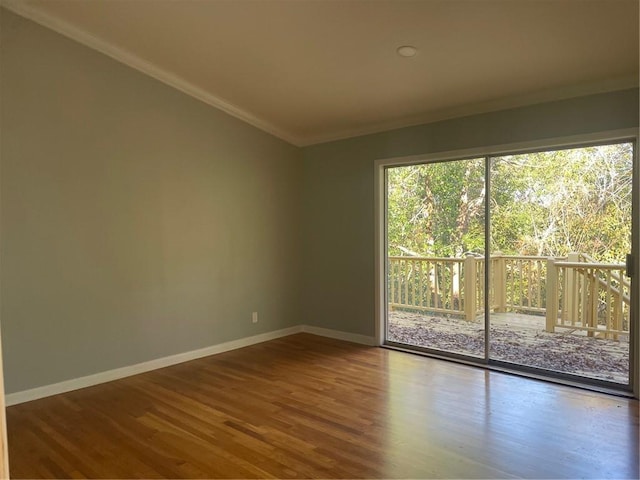 empty room with crown molding and hardwood / wood-style flooring