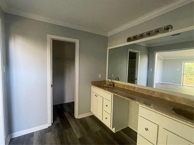 bathroom with crown molding, wood-type flooring, and vanity