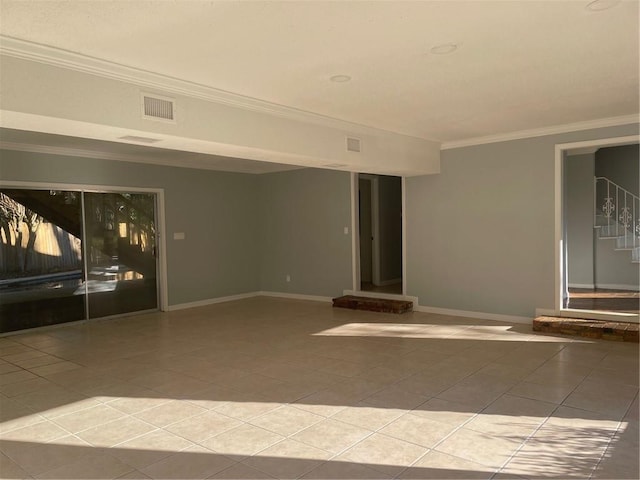 empty room featuring ornamental molding and tile patterned floors