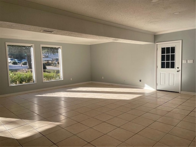 empty room featuring crown molding, a textured ceiling, and light tile patterned floors