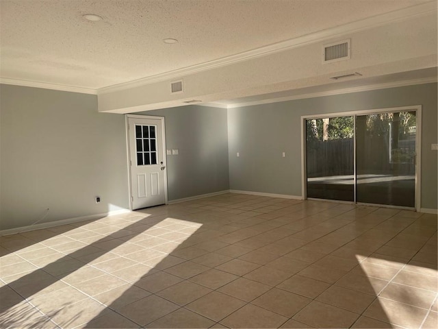 tiled empty room with ornamental molding and a textured ceiling