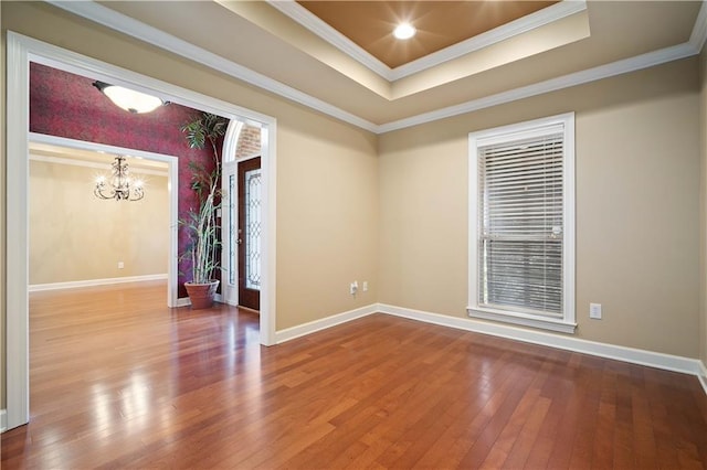 spare room featuring baseboards, crown molding, a tray ceiling, and hardwood / wood-style flooring