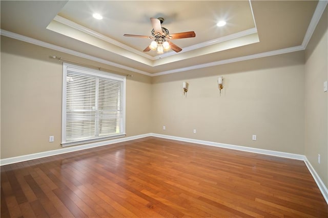 unfurnished room with baseboards, a raised ceiling, and hardwood / wood-style floors