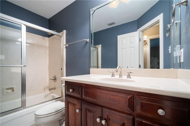 bathroom featuring visible vents, vanity, toilet, and shower / bath combination with glass door