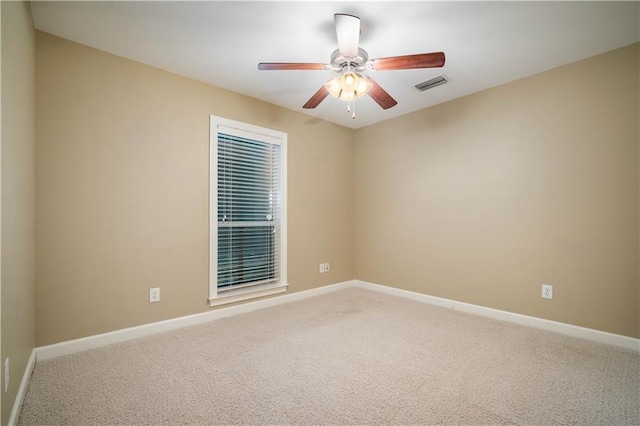 carpeted empty room with baseboards, visible vents, and ceiling fan