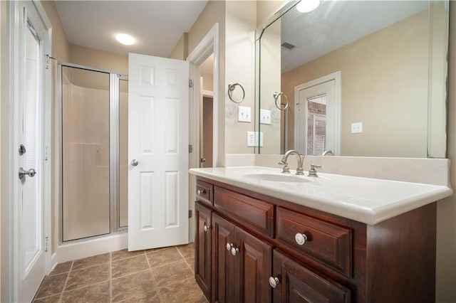 bathroom featuring vanity, visible vents, a stall shower, and tile patterned flooring