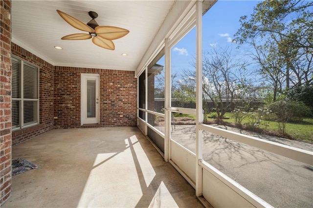 unfurnished sunroom featuring a ceiling fan