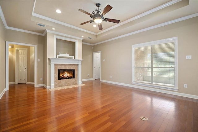 unfurnished living room with visible vents, a raised ceiling, baseboards, and wood finished floors