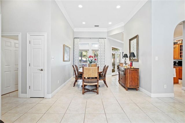 dining space featuring crown molding and light tile patterned flooring