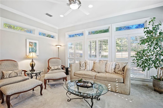 carpeted living room with ceiling fan and ornamental molding