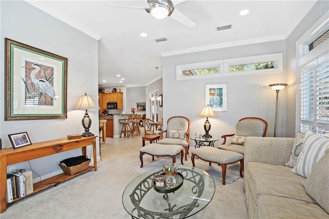 carpeted living room with ceiling fan, a wealth of natural light, and ornamental molding