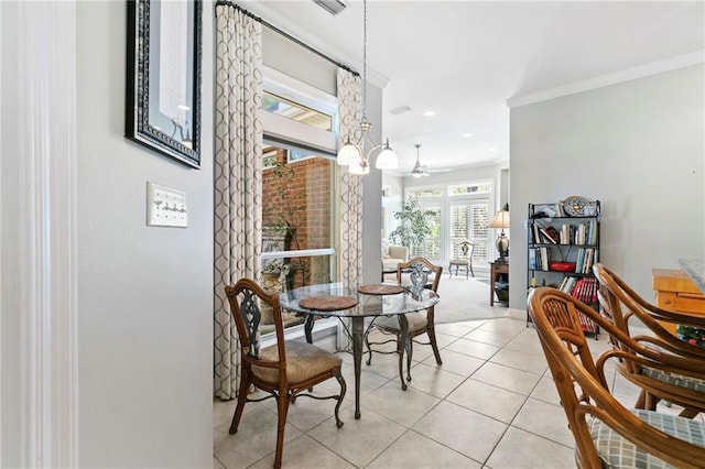 dining space with light tile patterned floors, ceiling fan with notable chandelier, and crown molding