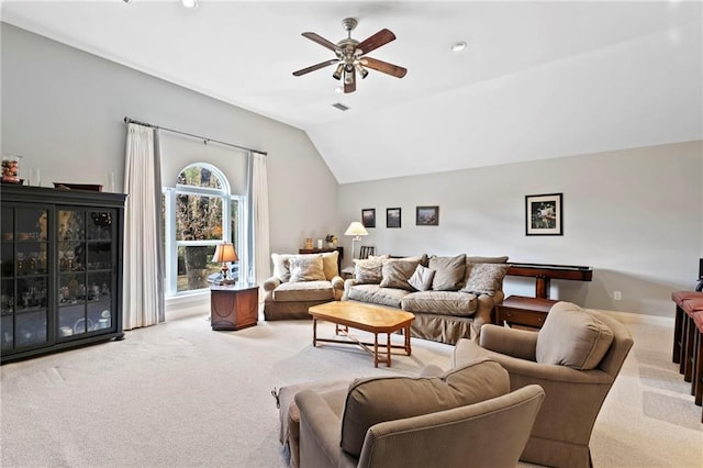 carpeted living room with ceiling fan and vaulted ceiling