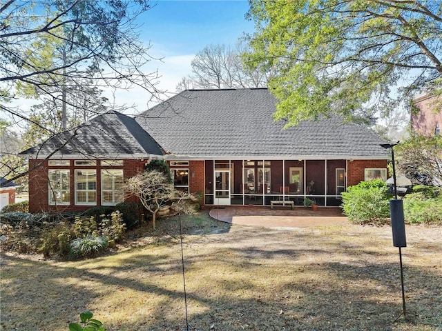 back of property with a patio area, a sunroom, and a yard