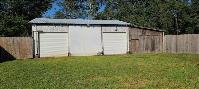 view of outdoor structure featuring a lawn and a garage