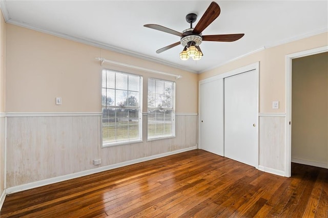 unfurnished bedroom with dark hardwood / wood-style flooring, a closet, ceiling fan, and ornamental molding