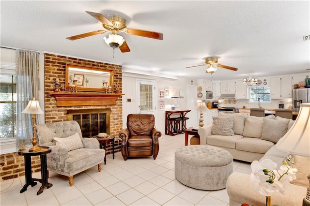 tiled living room with ceiling fan, a fireplace, a textured ceiling, and sink