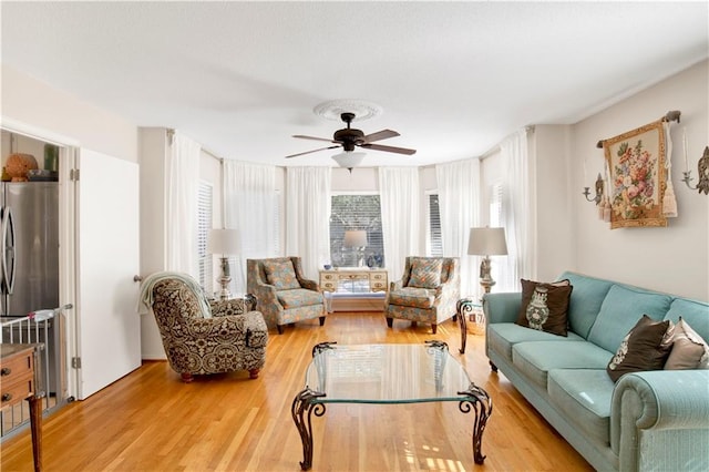 living room featuring ceiling fan and light hardwood / wood-style floors