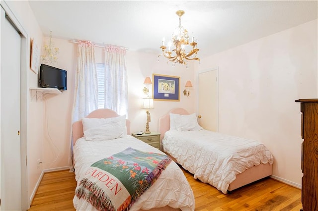 bedroom with hardwood / wood-style flooring, a closet, and a notable chandelier