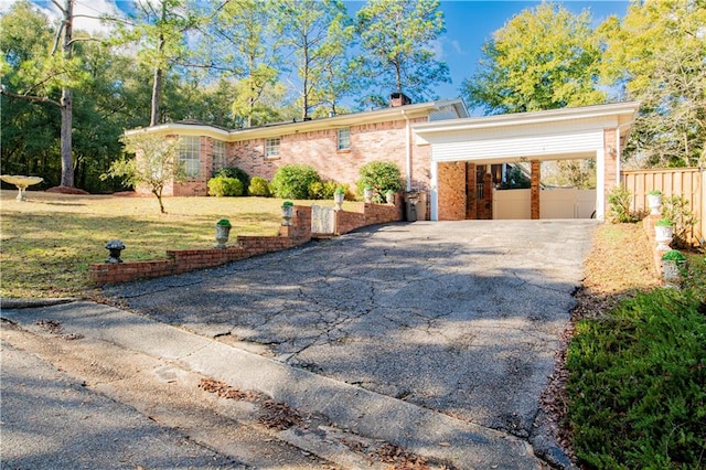 ranch-style home featuring a carport and a front lawn