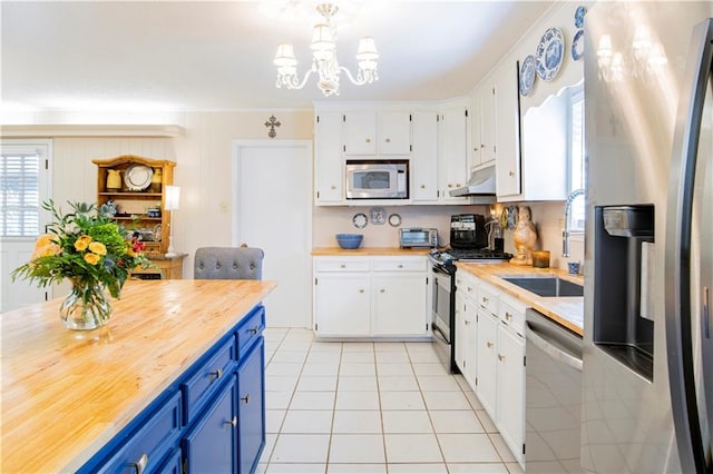 kitchen with white cabinets, blue cabinets, and stainless steel appliances