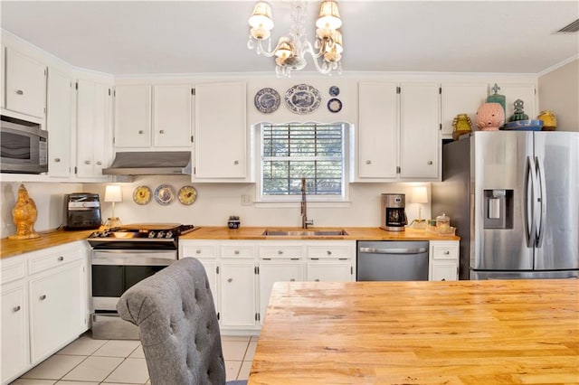 kitchen featuring white cabinets, sink, appliances with stainless steel finishes, decorative light fixtures, and light tile patterned flooring