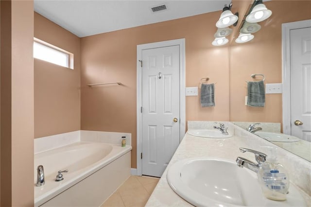 bathroom with vanity, a bath, and tile patterned floors