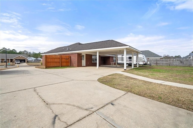 view of front of home with a carport and a front lawn