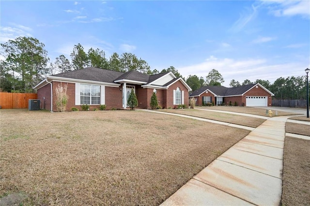 ranch-style home with cooling unit, a garage, and a front lawn