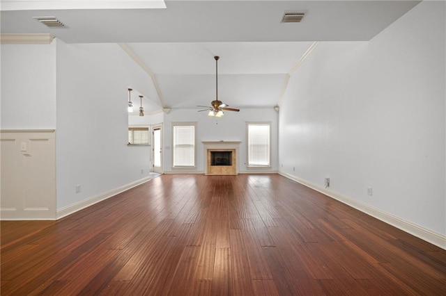 unfurnished living room featuring crown molding, dark hardwood / wood-style flooring, lofted ceiling, and a fireplace