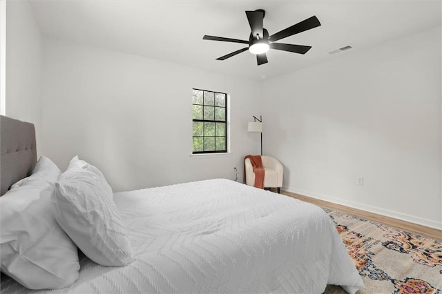 bedroom with visible vents, ceiling fan, wood finished floors, and baseboards