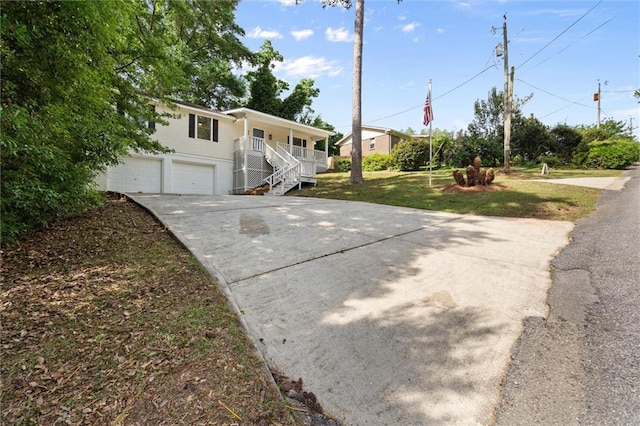 view of front of house featuring a porch, a front lawn, stairway, a garage, and concrete driveway