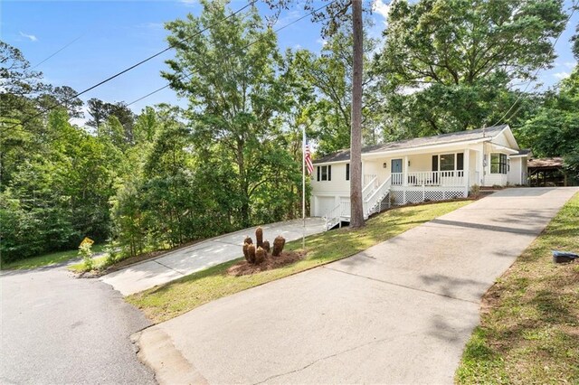 view of front of home featuring driveway, a garage, and covered porch